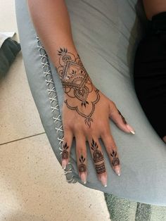 a woman's hand with henna tattoos on it