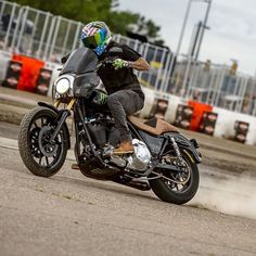 a man riding on the back of a motorcycle down a street