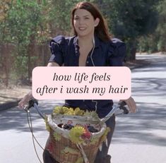 a woman riding a bike with a basket full of fruit on the front, and an ad that reads how life feels after i wash my hair