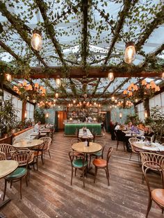 an indoor restaurant with tables and chairs covered in vines