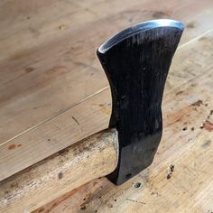 an old hammer is sitting on top of a wooden table