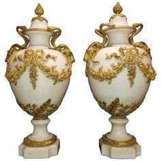 two white and gold vases sitting next to each other