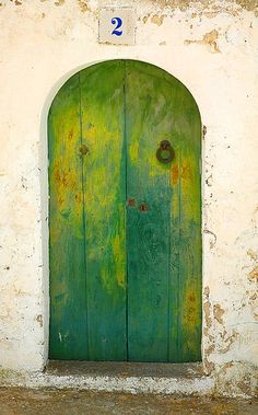 an old green door with a number two on it