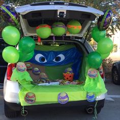 the trunk of a car decorated with balloons and decorations