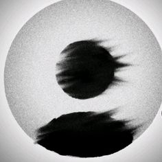 a black and white photo with blurry circles in the middle, one circle has an object on it's side