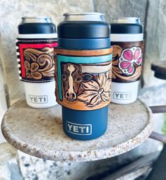 three yeti coffee cups sitting on top of a table