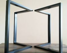 two metal frames sitting on top of a wooden table