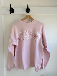 Soft pullover or hoody personalized to your greek letters, team name, town, zipcode, etc. using hand stitched applique technique. Floral design of the letters will very per item as each is made to order and based on what patterns I have available.  I will work with you and send you pictures of the exact fabric once the order is placed. I ask that you do not request words longer than 8 letters as the letters get to small after that in order to fit across the shirt. I will send a picture of the wo Pink Crew Neck Sweats With Letter Print, Embroidered Sorority Sweatshirts, Pink Relaxed Fit Sweatshirt With Letter Embroidery, Pink Cotton Sweatshirt With Letter Embroidery, Sorority Patchwork Sweatshirt, Pink Hooded Top With Letter Embroidery, Sorority Letters Sweatshirt, Sorority Stitched Letters Simple Sweatshirt, Letter Hoodie