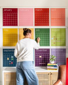 a woman standing in front of a calendar wall