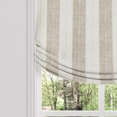 an open window with a striped roman blind in front of it and trees outside the window