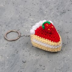 a crocheted keychain with a strawberry on it sitting on the ground