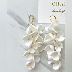 two white flowers are attached to gold ear wires