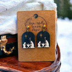 Remember the true meaning of Christmas with these dangle earrings. You will definitely want to see these in person. The shimmering navy acrylic creates the perfect for scene for Mary, Joseph and Baby Jesus.  Made from a navy shimmering acrylic that has been laser engraved and hand painted and connected with a gold plated stainless steel post to give it a pop of color. Nativity Clay Earrings, Christian Earrings, Mary Joseph And Baby Jesus, The True Meaning Of Christmas, Laser Ideas, Christmas Event, Wreath Hanger, Meaning Of Christmas, True Meaning Of Christmas