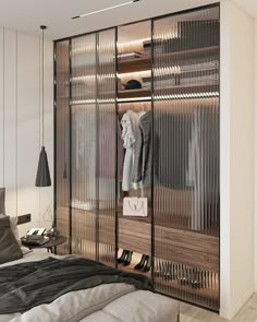 a bedroom with an open closet and clothes on hangers next to the bed in front of it