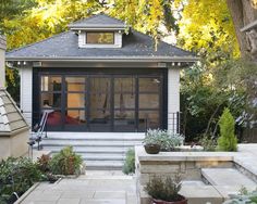 a small gray and white house with lots of windows