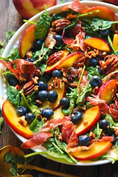 a salad with blueberries, peaches and pecans in it on a plate