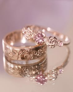 two wedding rings with pink stones on them