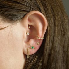 a woman wearing three different ear piercings