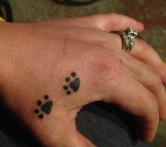 a person with a small tattoo on their left hand and paw prints on the wrist