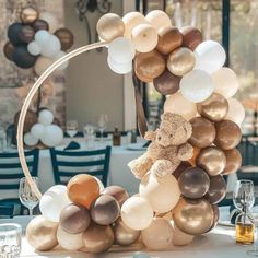 a teddy bear sitting on top of a bunch of balloons in the shape of a circle