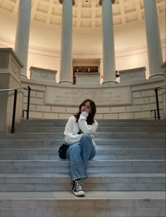 a woman sitting on the steps of a building