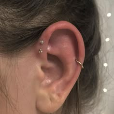 a close up of a person's ear with two piercings