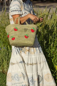 a woman carrying a wicker basket with strawberries on it