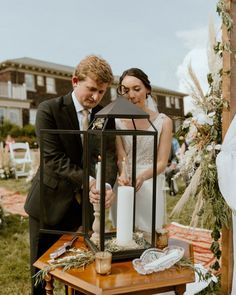 a man and woman standing next to each other in front of a lantern