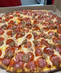 a pepperoni and sausage pizza in a box