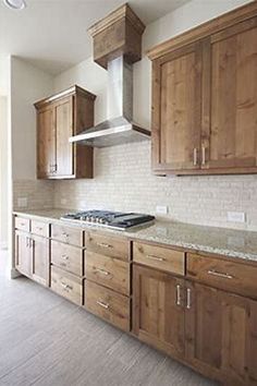 an empty kitchen with wooden cabinets and marble counter tops