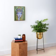 a potted plant sitting on top of a wooden table next to a metal stand