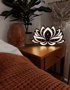 a wooden table with a lamp on top of it next to a potted plant