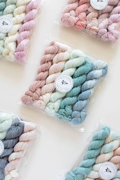 several skeins of yarn in plastic bags on a white surface with labels that say,