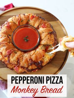 a person dipping sauce into a deep dish pizza on a wooden platter with red checkered table cloth