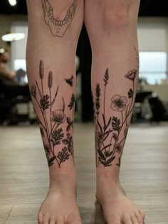 a woman's legs with flowers and a skull tattoo on her left leg,