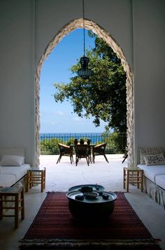 an open door leading into a living room and dining area with a view of the ocean