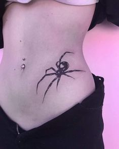 a woman with a spider tattoo on her stomach