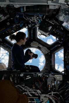 a woman sitting in the window of a space station