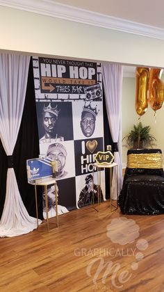 a stage set up for a hip hop event with gold balloons and black drapes