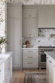 a kitchen with white cabinets and floral wallpaper