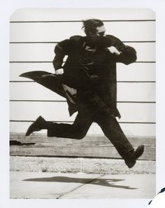 a black and white photo of a man jumping in the air