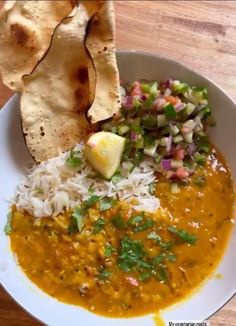 a white bowl filled with food next to tortilla chips and cole slaw