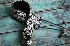 a black and white tie laying on top of a blue wooden floor next to scissors