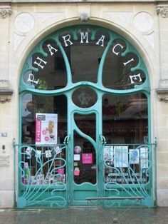 the front entrance to a pharmacy with an iron gate and sign on it's glass door