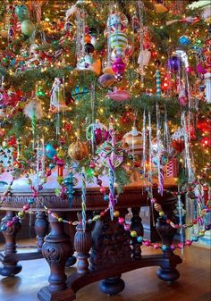 a christmas tree with ornaments hanging from it's branches and lights on the top