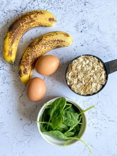 bananas, oatmeal, eggs and spinach on a table