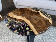 a wooden table sitting on top of a carpeted floor next to a white couch