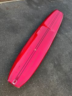 a red surfboard laying on the ground