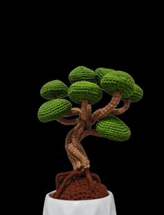 a crocheted bonsai tree sitting on top of a white pot filled with dirt