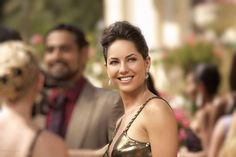 a woman in a gold dress smiling for the camera